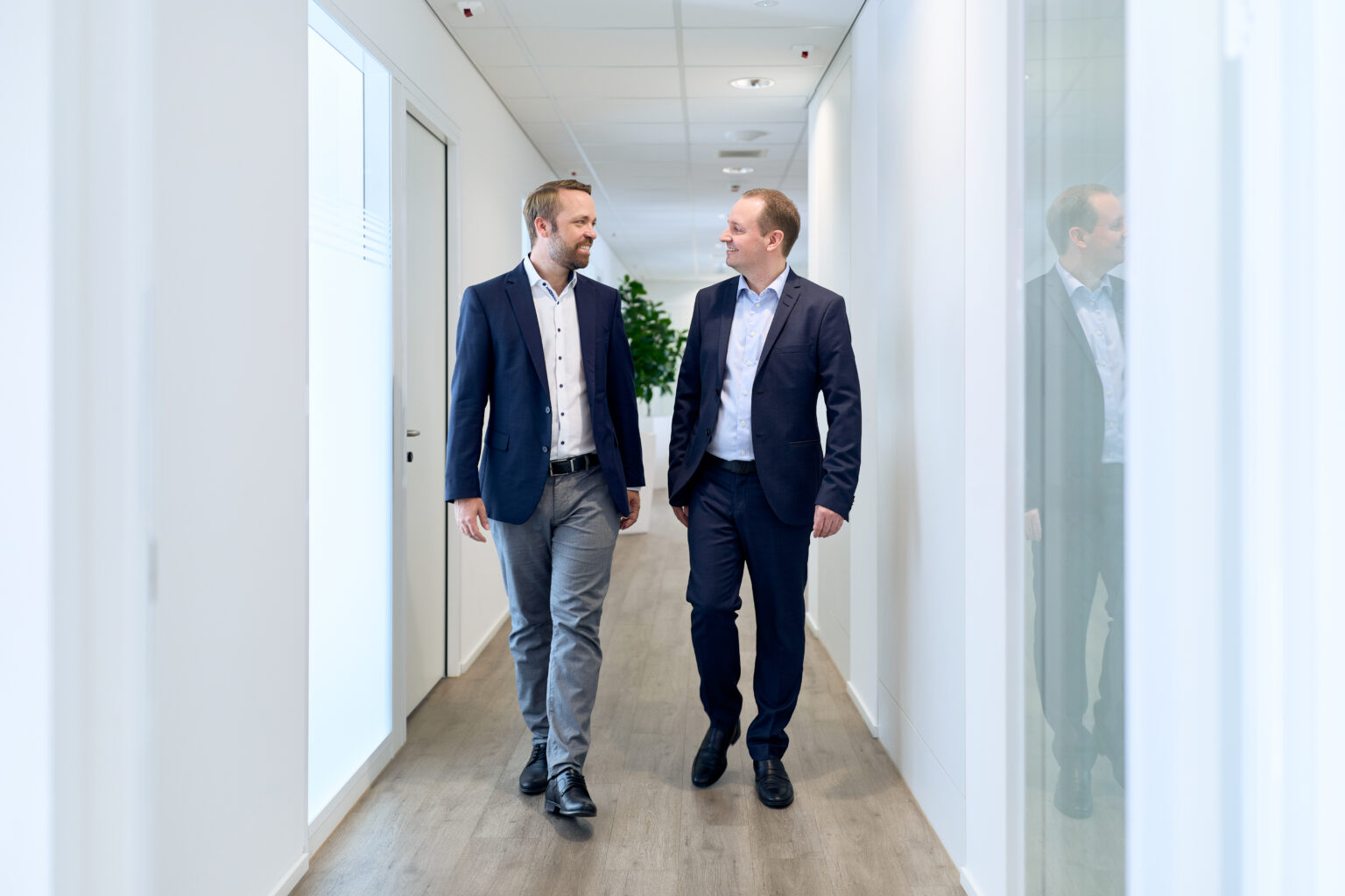 Morris Jud und eine Führungskraft laufe im Gang